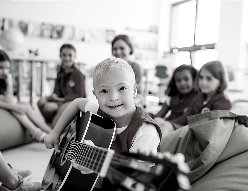 Un enfant assis en groupe utilisant une guitare