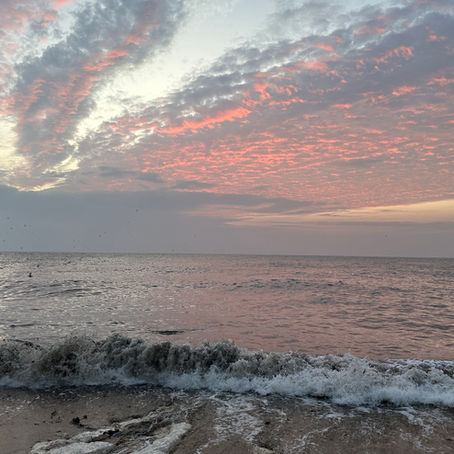 Sunrise at Flamborough Head, Bridlington UK on a cloudy day with soft pale pink sky—peaceful coastal scene inviting mindful reflection and gentle calm.