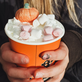 Child holding hot chocolate with marshmallows in autumn pumpkin setting — cosy fall drink, mindful family moments, seasonal comfort and gratitude.