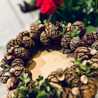 Natural pinecone Christmas wreath crafted by hand, arranged in soft indoor light, symbolising calm and slow living.
