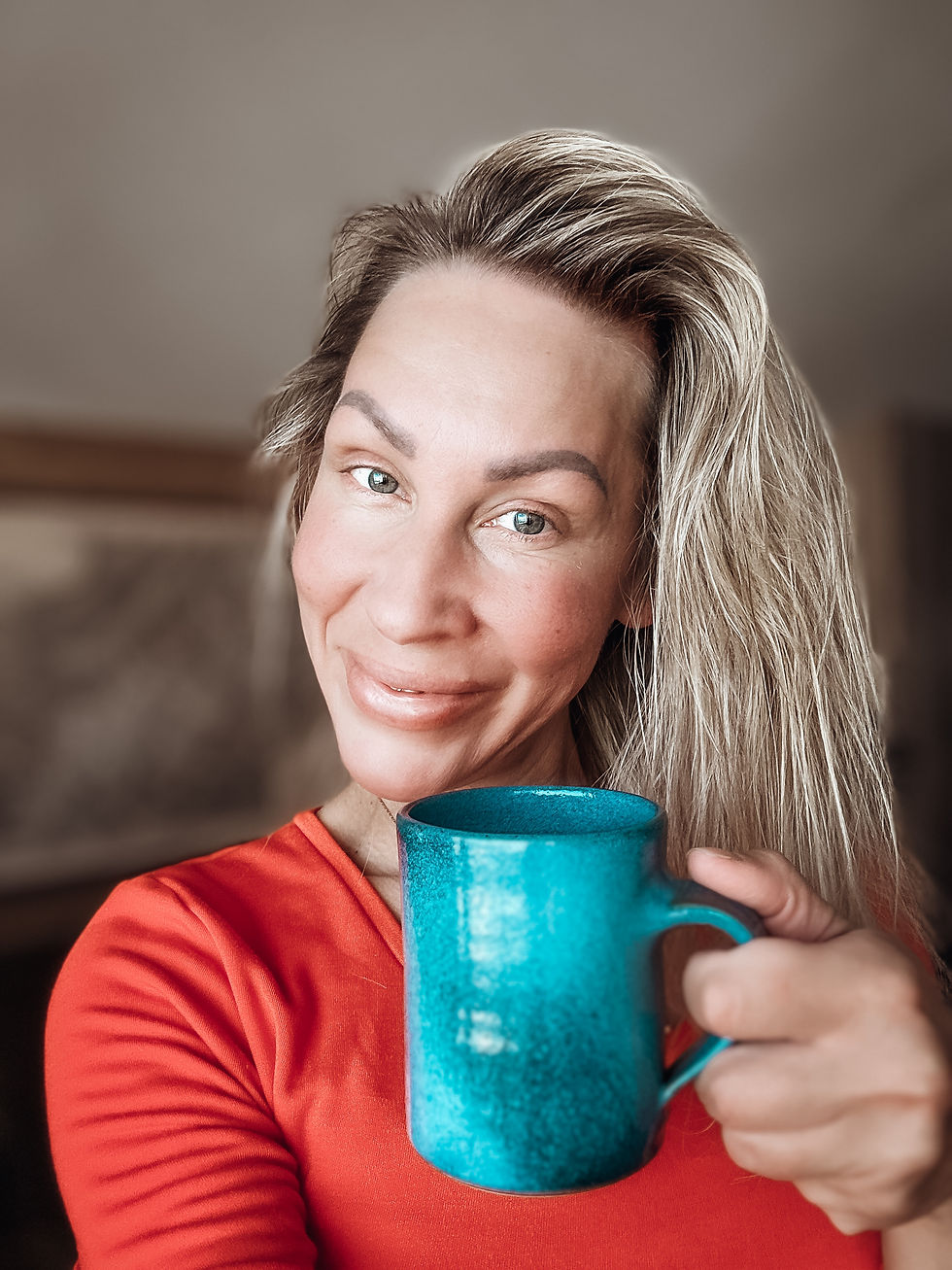 Lady warm and mindful smile in a camera, holding a cup of coffee. She radiating joy and positivity