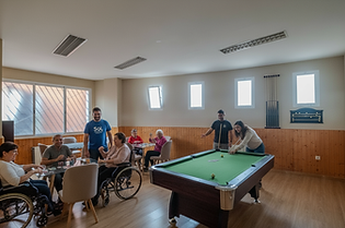 Fill_the__game_room__with_10_12_people_engaged_in_various_games__creating_a_happy_and_incl