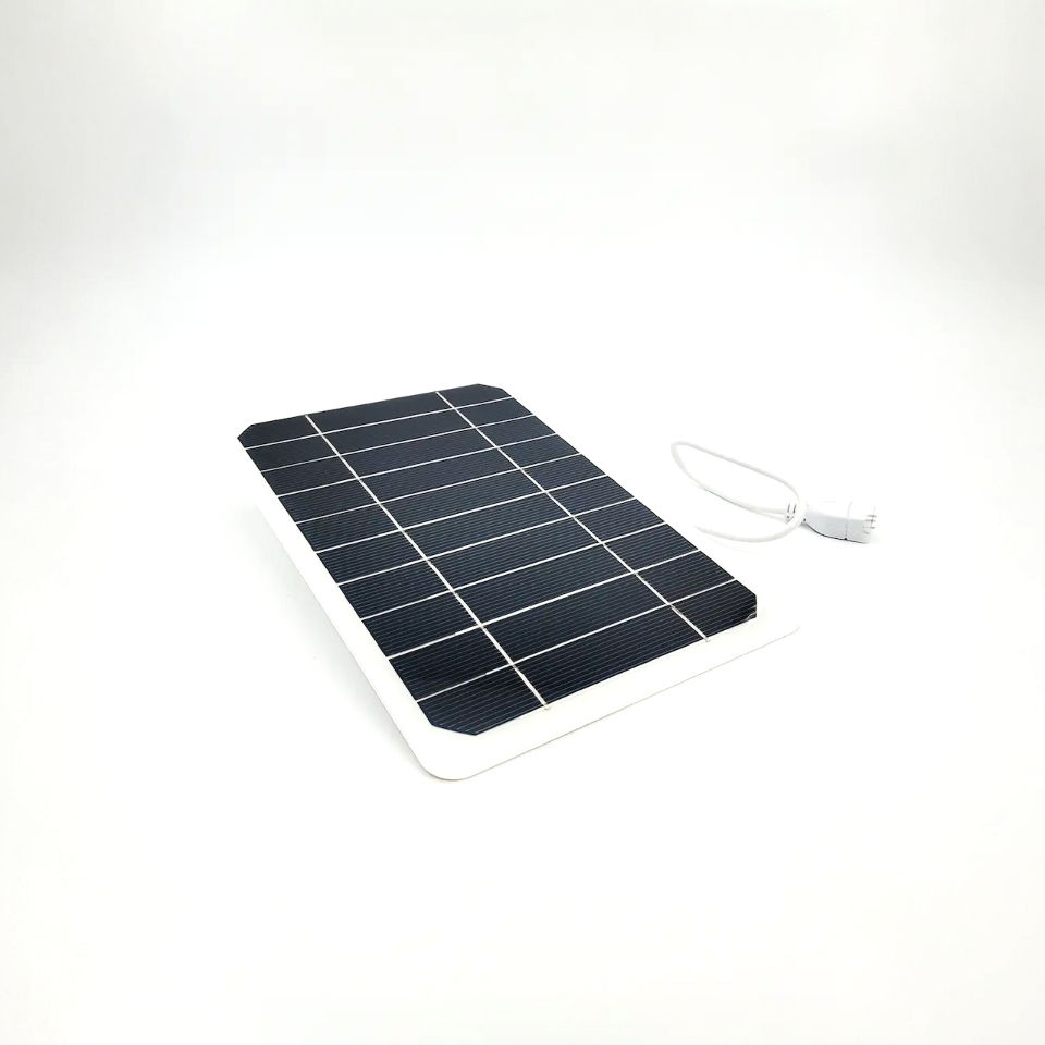 Chargeur solaire posé au sol avec son cordon d'alimentation