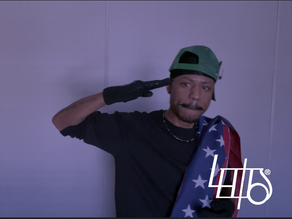 LEWDO, labeled The SUPERvillain, salutes the world with the American flag over his shoulder inside the Lair — portrayed as the Boogeyman’s Nightmare and a Predator to Predators, emerging when Justice is Denied & Accountability Disappears.