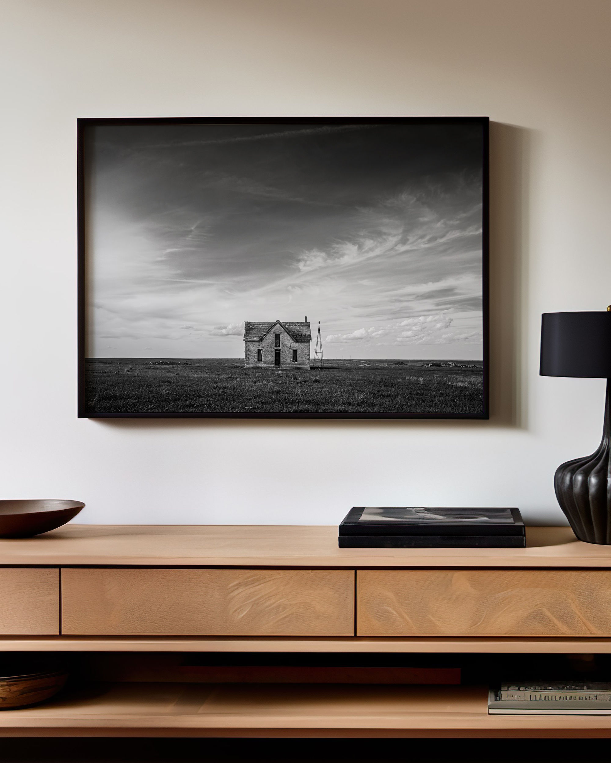 black and white photo of a farm house in a frame above a wood shelf