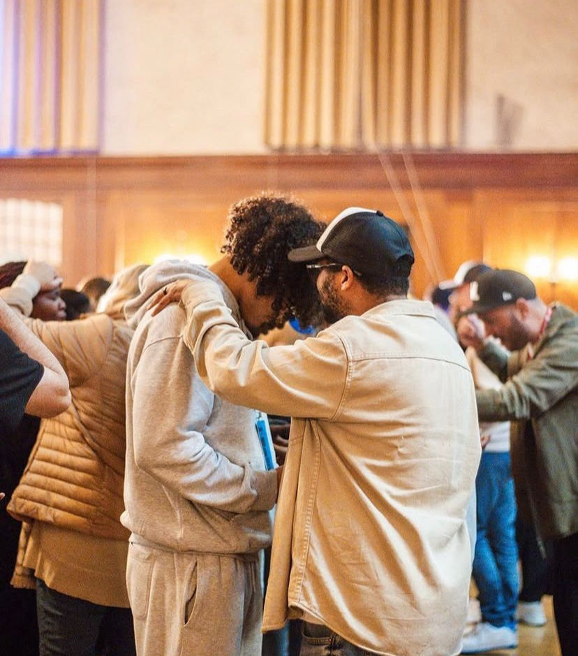 Marco praying over a young man (Nights of Anointing).