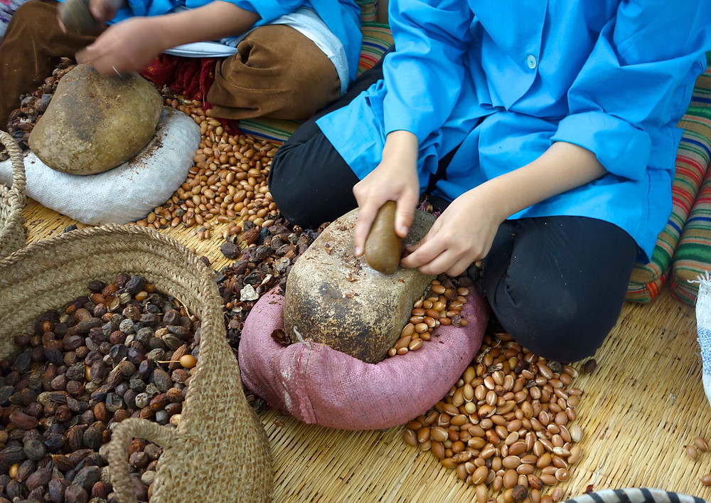 Women breaking open argan husks