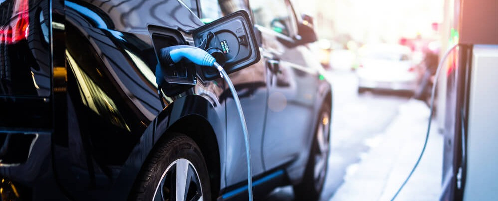 Electric car at a charging station. Learn about home charging stations.