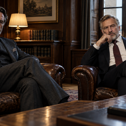Two elegant men are sitting in an elegant office.