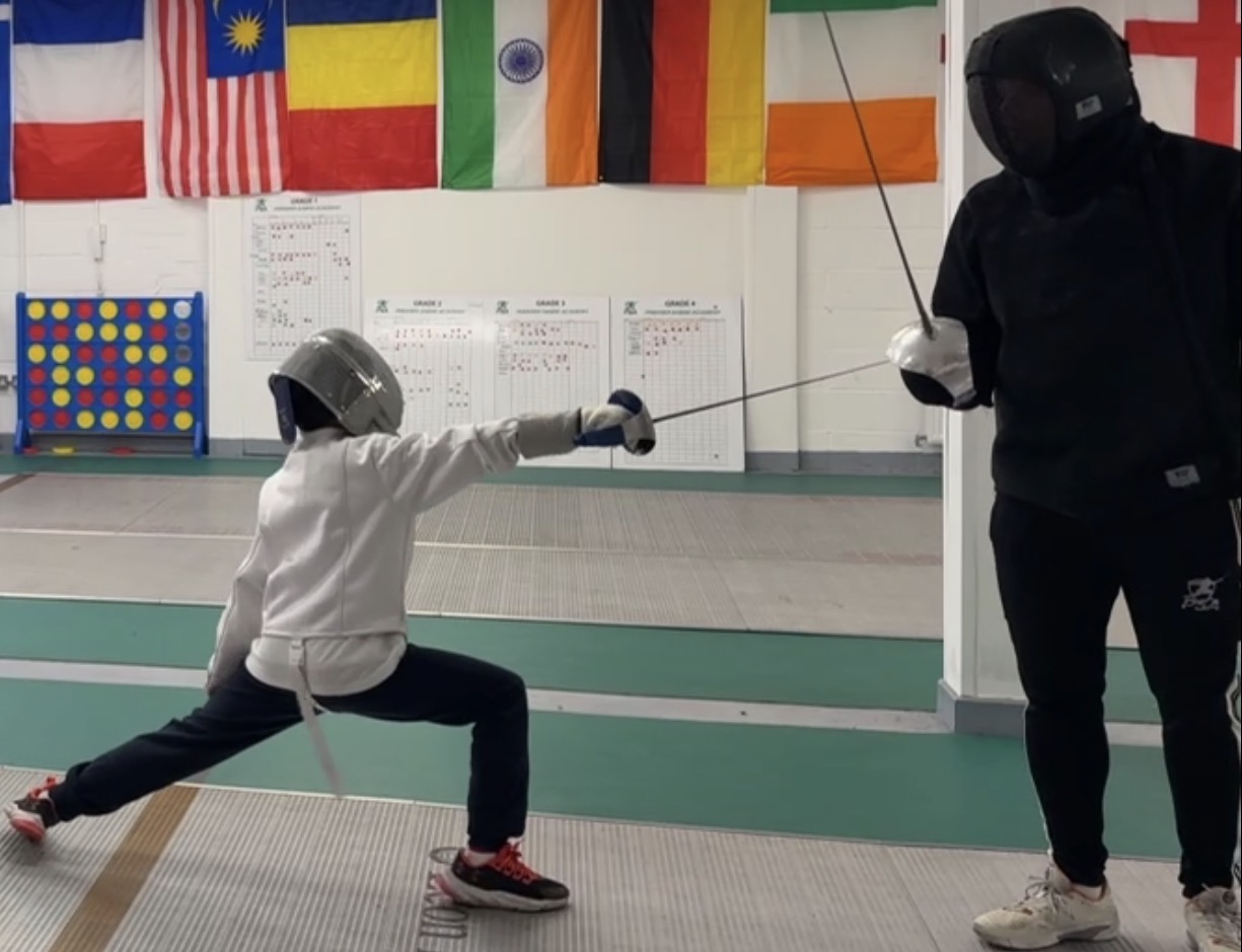 A professional fencing sabre resting on a sleek metallic surface in the training facility.