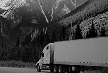 Freight truck driving through mountainous terrain, symbolizing nationwide shipping, carrier fleet operations, and supply chain movement.