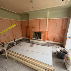 Room with a fireplace and plasterboard stacked on the floor
