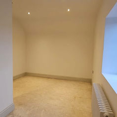 Empty room with smooth plastered walls and a radiator