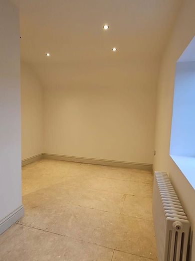 Empty room with smooth plastered walls, skirting board and a radiator