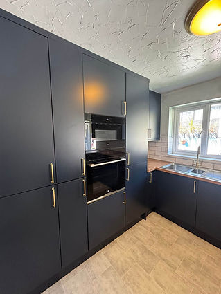 Bespoke navy fitted kitchen cabinetry with integrated oven and microwave