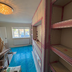 Room with built-in shelving and a blue protective floor covering