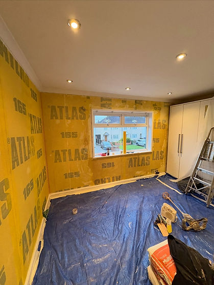 Room with protected walls and floor covered in plastic ready for plastering