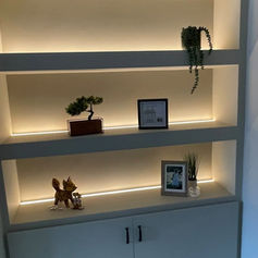 Built-in shelving with warm LED lighting and decorative ornaments