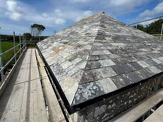 Slate roof with safety walkway and netting during roofing work