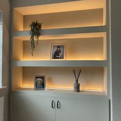 Built-in alcove shelves with warm lighting and plants