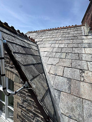 Close-up of slate roof edge and guttering during a roofing project