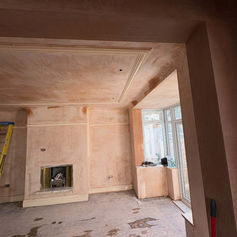 Bay window room with a fireplace and fresh plaster