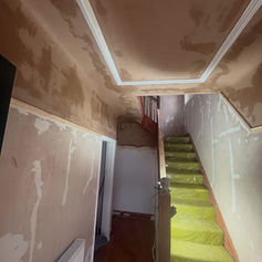 Stairwell with newly plastered walls and coving
