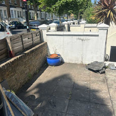 Cleared yard with paving and walls after waste removal
