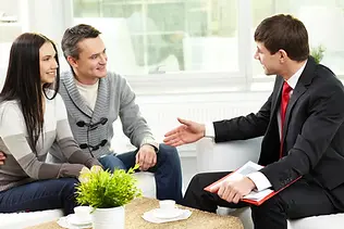 Mortgage adviser shaking hands with clients after successful consultation