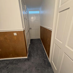 Hallway with fresh plastered walls and dark carpet