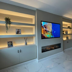 Wall-mounted television with alcove shelving and LED lighting