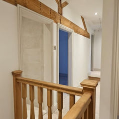 Staircase with a wooden banister and plastered walls