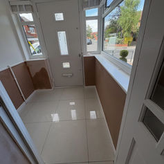 Bright hallway with plastered walls and a front door