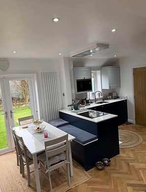 Renovated black fitted kitchen with dining table and garden views