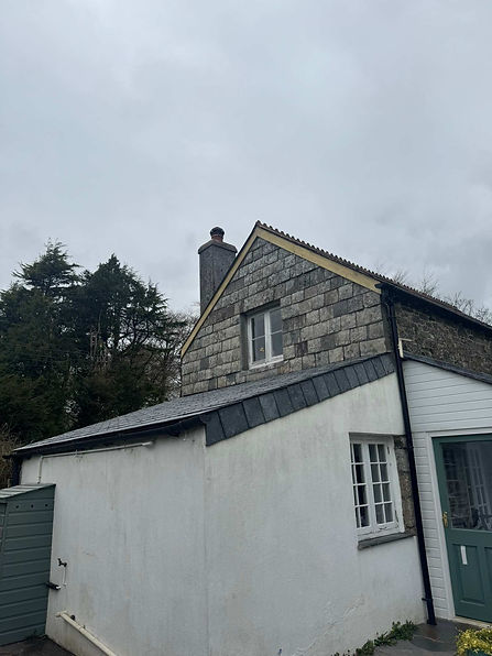 Slate roofed barn conversion with chimney set among trees near Tavistock