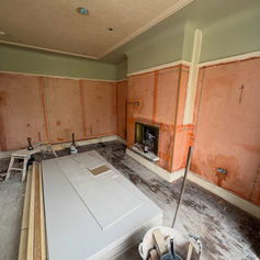 Room with a fireplace and plastered walls ready for finishing