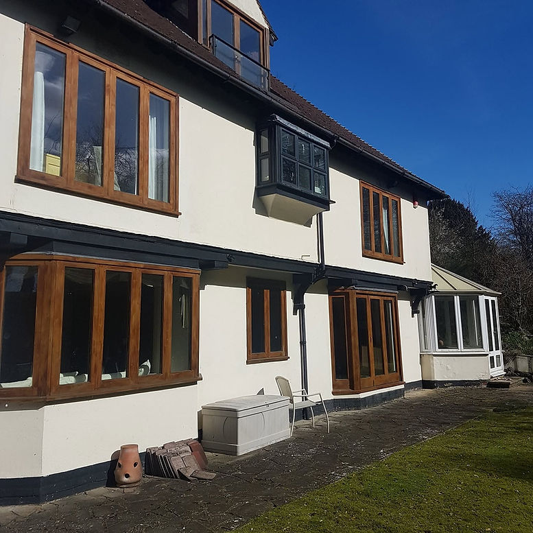 Rendered exterior wall with timber framed windows and conservatory