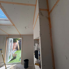 Plastered room with an open door leading to a garden