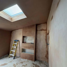Room with a skylight, plastered walls and a stepladder