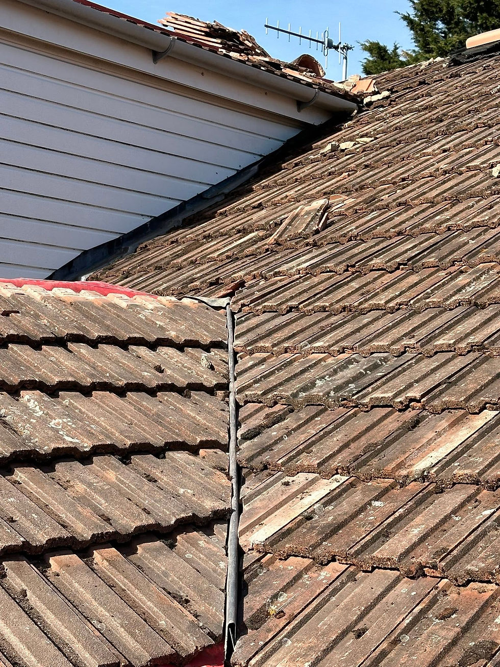 Lead valley flashing between two roof sections with worn tiles nearby