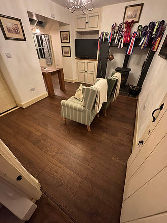 Renovated hallway with dark wooden flooring and wall-mounted coat hooks