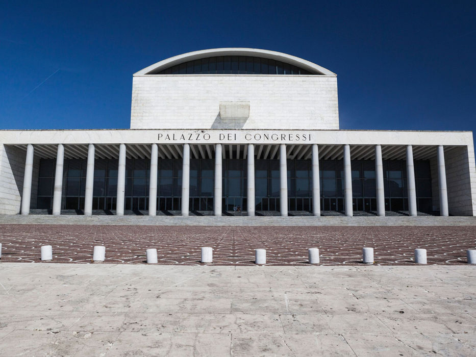 Front façade of Palazzo dei Congressi in EUR Rome with colonnade under blue sky