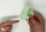 Folding the butterfly gently in half along the center line.