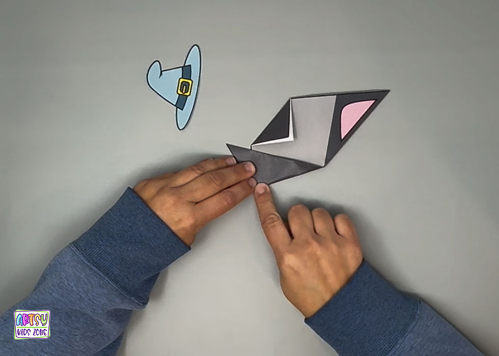 Folding the ears on the witch origami cat.