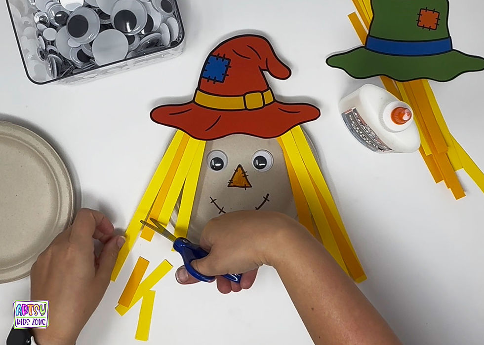 Trimming the paper hair on the paper plate scarecrow.