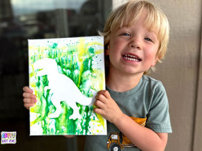 Boy holding his completed Tyrannosaurus Rex water gun paintiing.