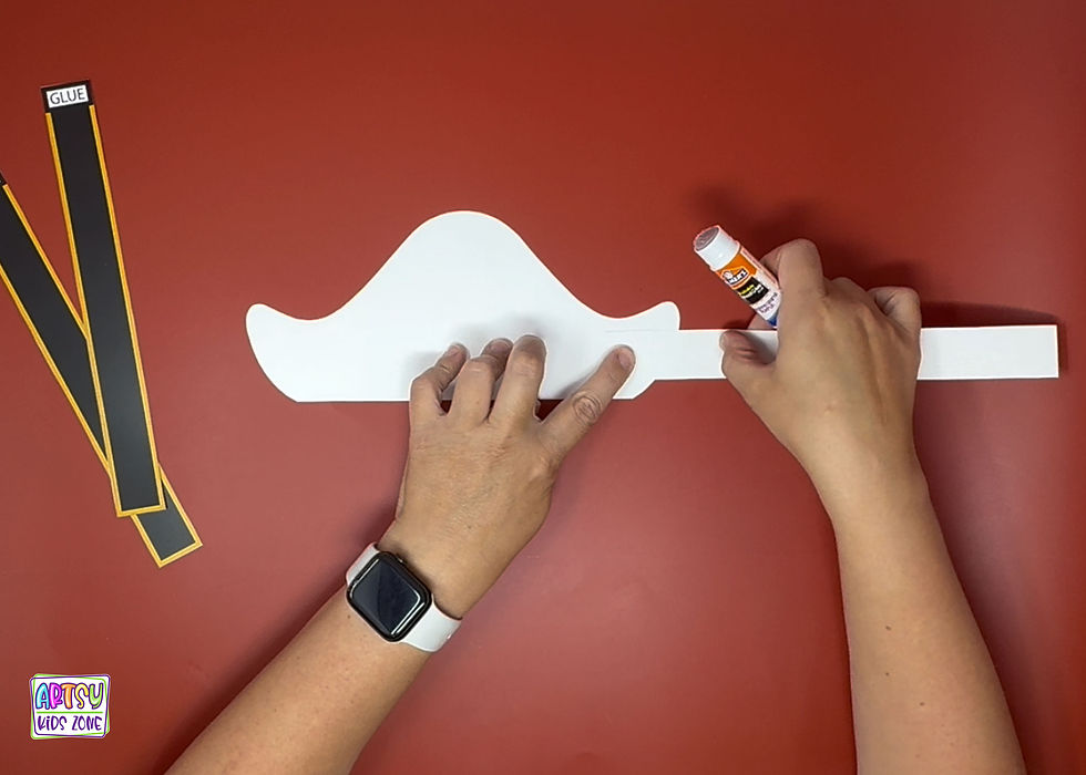 Assembling the paper pirate hat.