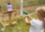 Girl painting with water guns.