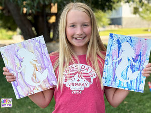 Girl holding completed Mermaid Water Gun Paintings.