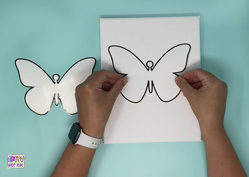 Placing homemade butterfly sticker onto canvas.